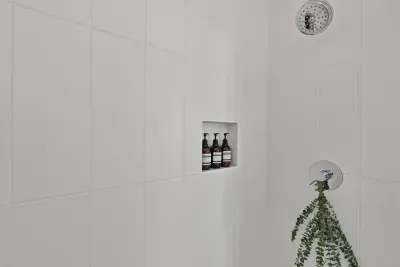 Spa-like soaps are provided for hair and body. Step into this shower and you'll notice the matte white tiles and channel drain which gives a modern invisible appearance.