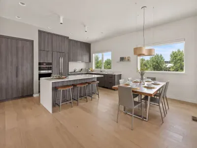 Bright modern kitchen with waterfall island, dining for 6, and sunny views