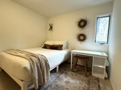 Cozy minimalist bedroom with natural light and a handy workspace