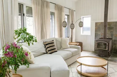 Sun-filled lounge with plush sectional and cozy wood-burning stove