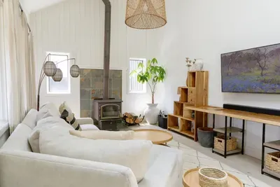 Bright vaulted living room with cozy wood stove and plush sectional