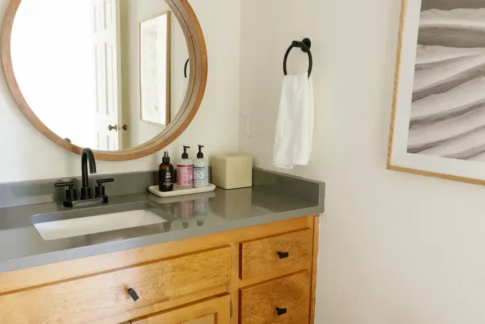 Bright modern bathroom vanity with round mirror and sleek black accents