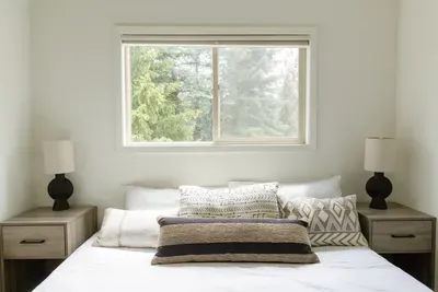 Bright minimalist bedroom with forest views and natural light