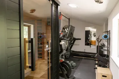 Private sauna and fitness room with cardio gear and wellness amenities