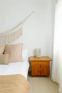 Bright minimalist bedroom with soft linens and warm wood accents