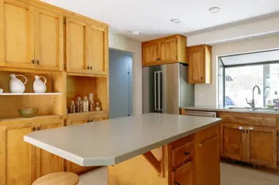 Bright kitchen with large island, warm wood cabinetry, and natural light