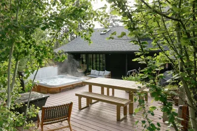 Private wooded deck with hot tub, dining area, and peaceful lounge seating