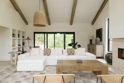 Bright designer living room with garden views, fireplace, and cozy seating