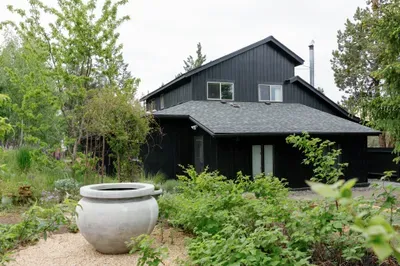 Stylish black home nestled in lush gardens for a peaceful nature escape