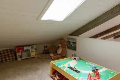 Cozy kids’ loft with skylight, books, toys, and a fun train table