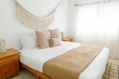 Bright, cozy bedroom with soft neutrals and abundant natural light