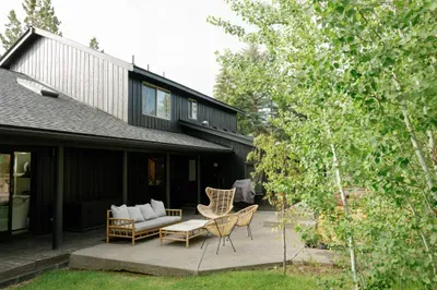 Private tree-lined patio with stylish lounge seating and outdoor grill