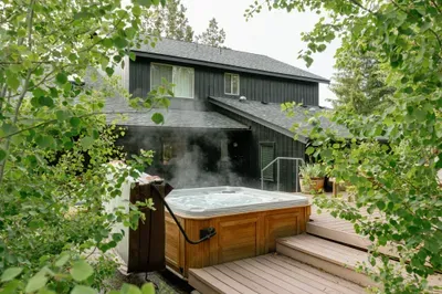 Private steaming hot tub on a serene wooded deck with cozy modern cabin charm
