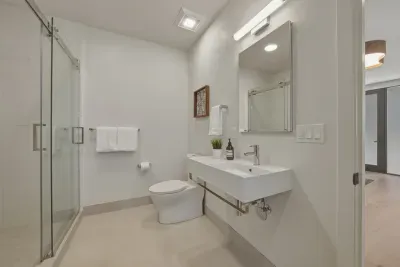 Bright modern bathroom with glass shower and sleek floating vanity