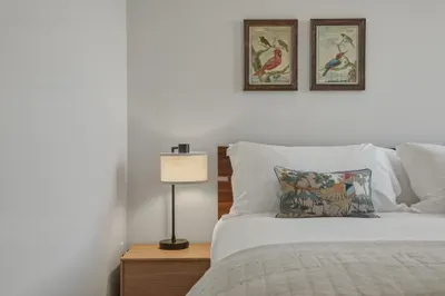 Bright, serene bedroom with plush bedding and elegant nature-inspired decor