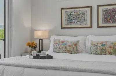Bright, stylish bedroom with floral accents and a cozy breakfast-in-bed touch