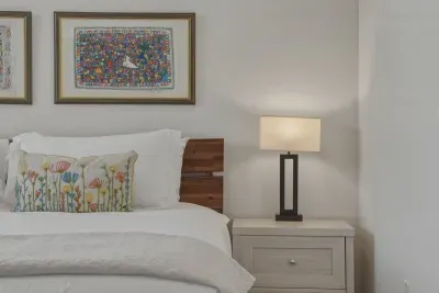 Cozy, art-filled bedroom with crisp linens and warm bedside lighting