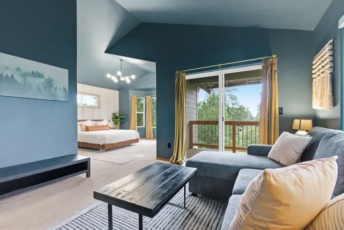 Bright open suite with cozy lounge, king bed, and private balcony views