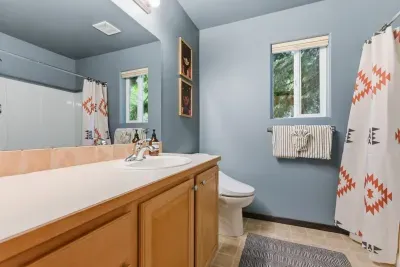 Bright, stylish bathroom with full tub-shower and serene window views