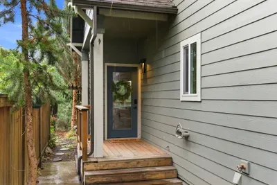 Private, tree-lined entry with covered porch and modern front door