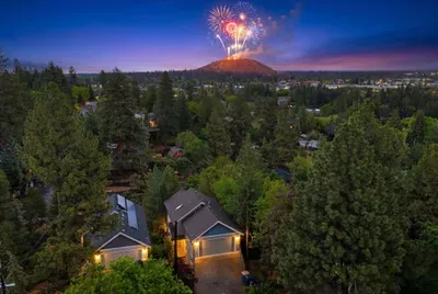 Twilight forest retreat with neighborhood views and fireworks in the distance