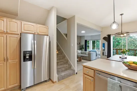 Bright open kitchen with stainless appliances and scenic natural views