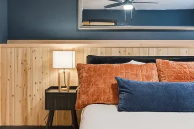 Cozy modern-rustic bedroom with warm wood accents and plush bedding