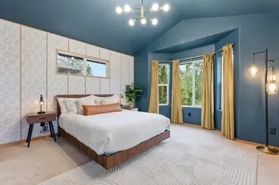 Bright king bedroom with vaulted ceilings and serene bay window views