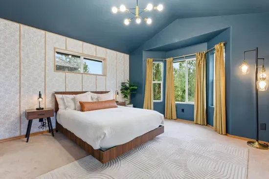 Bright king bedroom with vaulted ceilings and serene bay window views