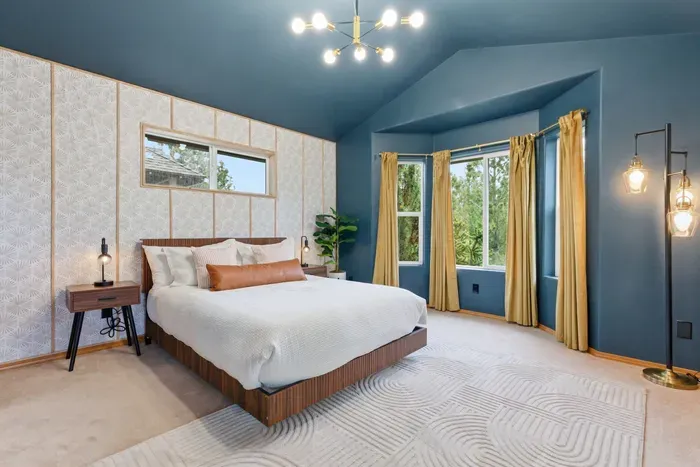 Bright king bedroom with vaulted ceilings and serene bay window views