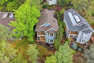 Aerial view of a private, tree-lined home with inviting decks