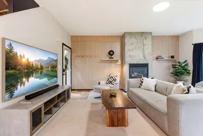Bright modern living room with fireplace, large TV, and cozy seating