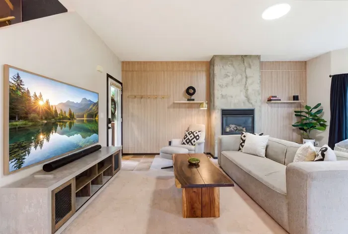 Bright modern living room with fireplace, large TV, and cozy seating