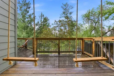 Peaceful wooded deck with twin swings and relaxing treetop views