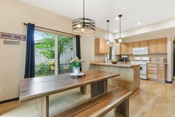 Bright open dining & kitchen space with breakfast bar and patio access