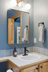 Bright, stylish bathroom vanity with modern lighting and warm wood accents