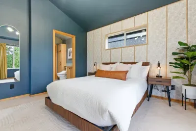 Modern king bedroom with high ceilings and ensuite bath access