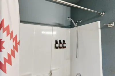 Clean modern shower with stocked bath essentials and stylish accents