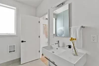 Luxurious and spacious full bathroom with walk in shower, toilet, sink, mirror, and laundry area. Soaps and towels provided.