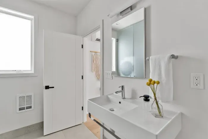 Luxurious and spacious full bathroom with walk in shower, toilet, sink, mirror, and laundry area. Soaps and towels provided.