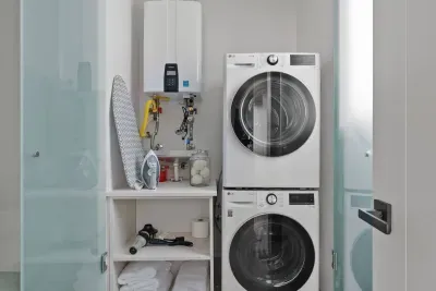 Private laundy area with full washer and dryer for guest use along with detergent and ironing gear. You can also find extra towels, hair dryer, and bathroom supplies here.