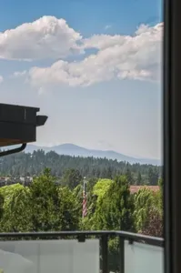 Scenic balcony views with treetops, mountains, and big open skies