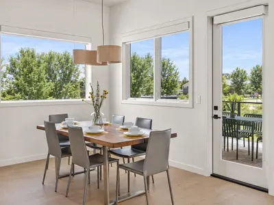 Sunny dining space for 6 with big windows and patio access