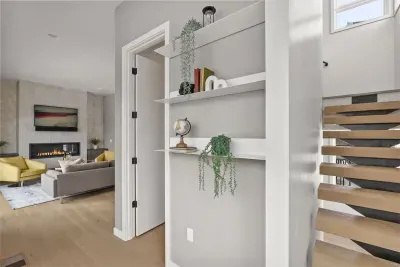 Bright modern entry with designer shelving, fireplace lounge, and open stairs