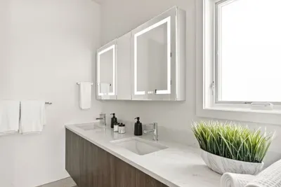 Bright double-vanity bathroom with LED mirrors and natural light