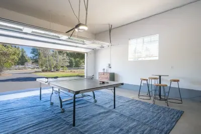 Ping pong table and bar seating nearby inside the spacious and clean garage