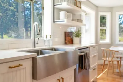 Farmhouse stainless steel sink looks out to beautiful treed yard