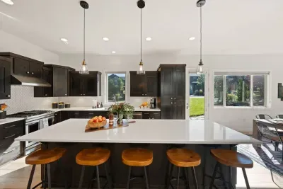 Full kitchen with quartz countertops, open to living and dining areas, island seating for 5. Kitchen is stocked with coffee, coffee maker (drip), basic seasonings, pots, pans, serveware, dishes, utensils, and kitchen appliances small and large!