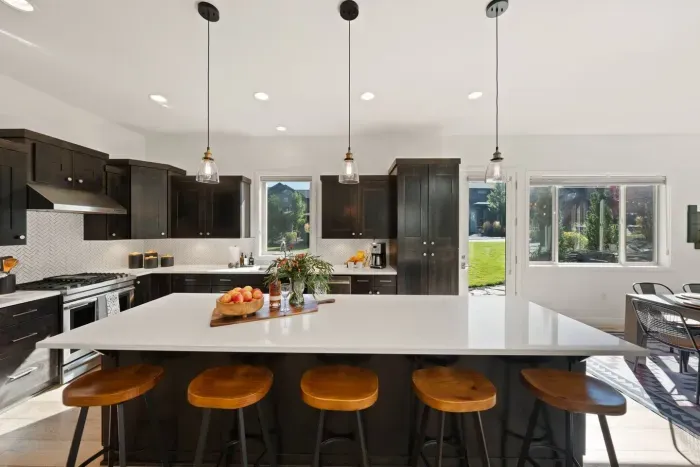 Full kitchen with quartz countertops, open to living and dining areas, island seating for 5. Kitchen is stocked with coffee, coffee maker (drip), basic seasonings, pots, pans, serveware, dishes, utensils, and kitchen appliances small and large!