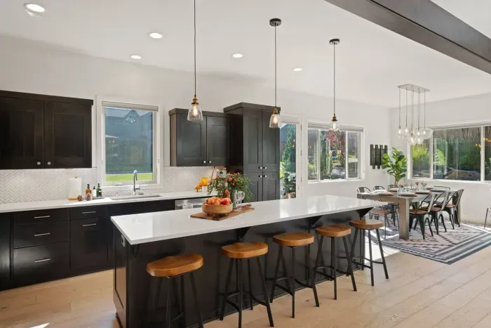Full kitchen with quartz countertops, open to living and dining areas, island seating for 5. Kitchen is stocked with coffee, coffee maker (drip), basic seasonings, pots, pans, serveware, dishes, utensils, and kitchen appliances small and large!